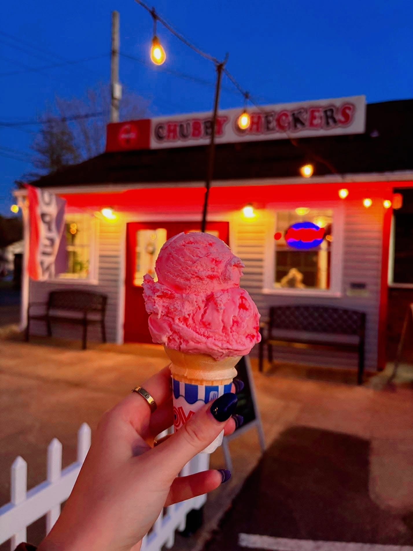 Ice cream cone in front of Chubby Checkers at dusk with string lights