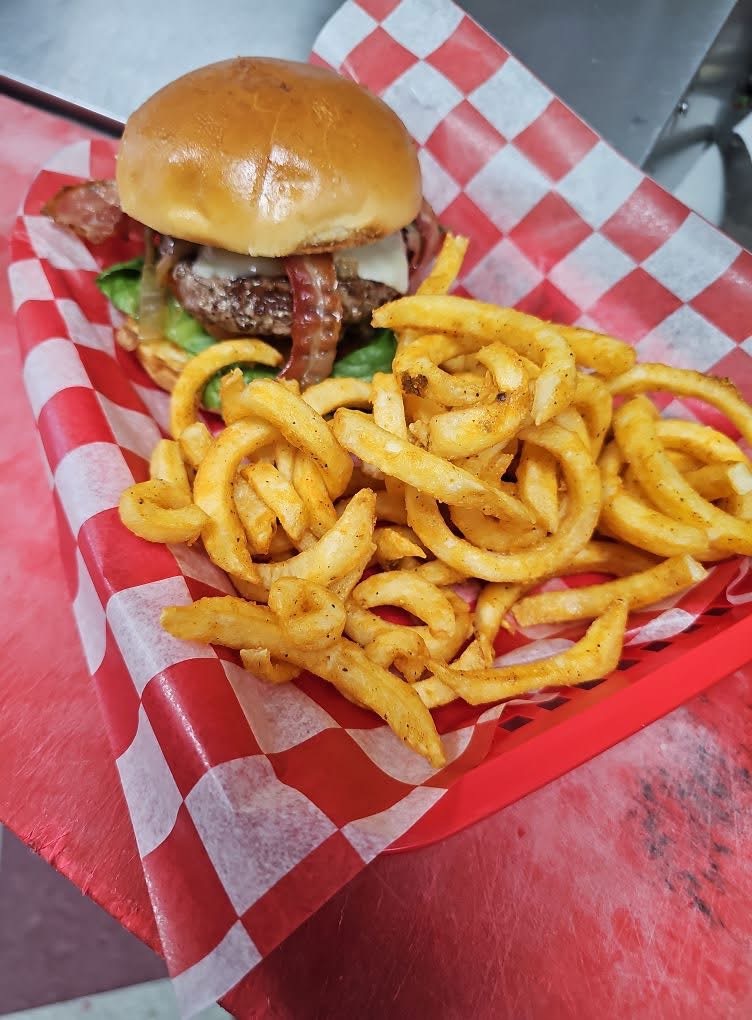 Bacon cheeseburger with curly fries in a red basket at Chubby's