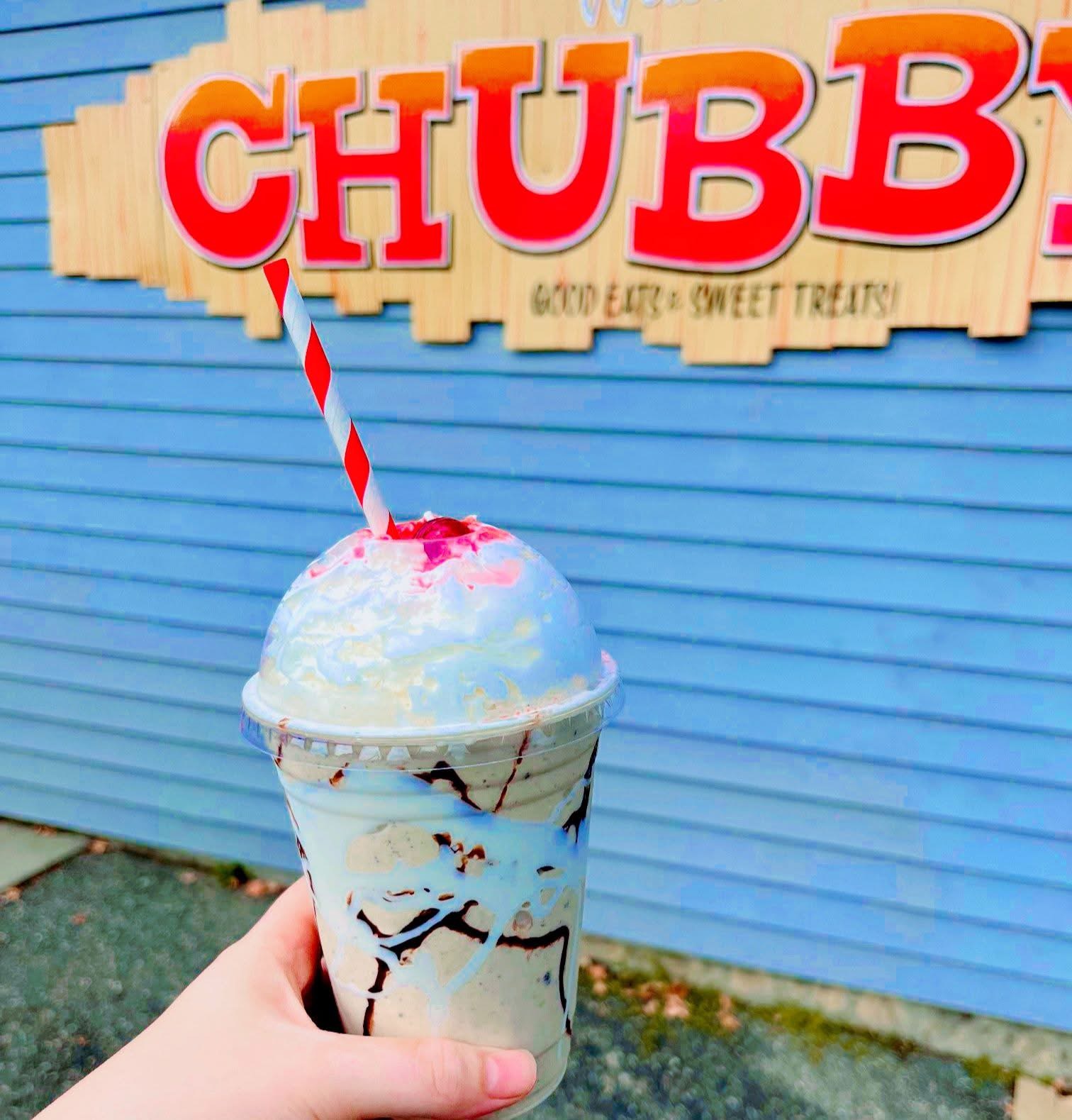 Cookies and cream shake with whipped cream in front of the Chubby's sign